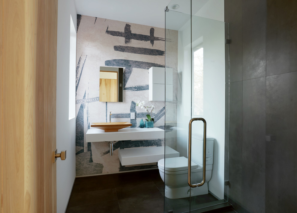 This is an example of a small contemporary 3/4 bathroom in Los Angeles with a vessel sink, open cabinets, white cabinets, a corner shower, white walls, a two-piece toilet, porcelain floors and solid surface benchtops.