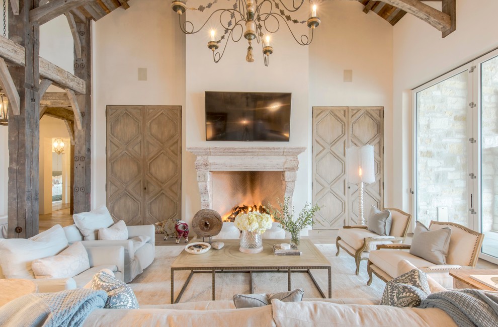 Design ideas for a country open concept family room in Austin with white walls, light hardwood floors, a standard fireplace and a wall-mounted tv.