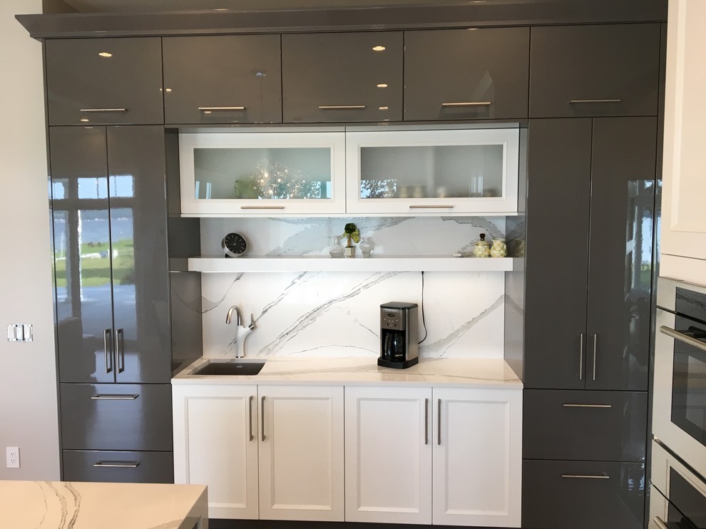 This is an example of a mid-sized modern single-wall open plan kitchen in New York with an undermount sink, shaker cabinets, white cabinets, stone slab splashback, stainless steel appliances, light hardwood floors and with island.