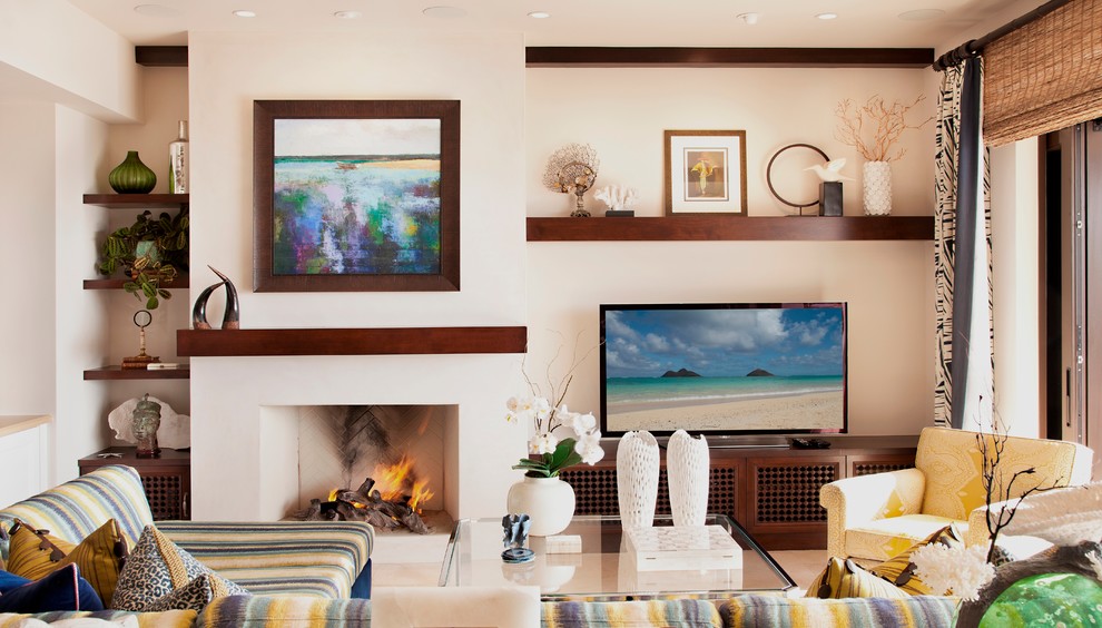 Inspiration for a large eclectic open concept living room in Orange County with white walls, travertine floors, a standard fireplace, a plaster fireplace surround and a built-in media wall.