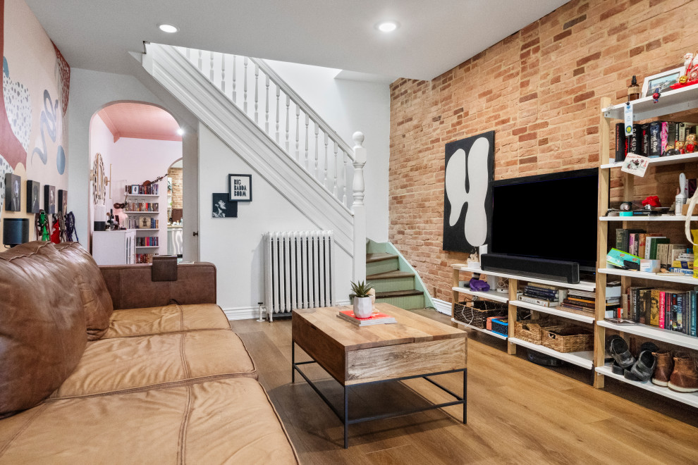 Immagine di un piccolo soggiorno eclettico aperto con sala formale, pareti beige, pavimento in vinile, TV autoportante, pavimento marrone e soffitto a volta