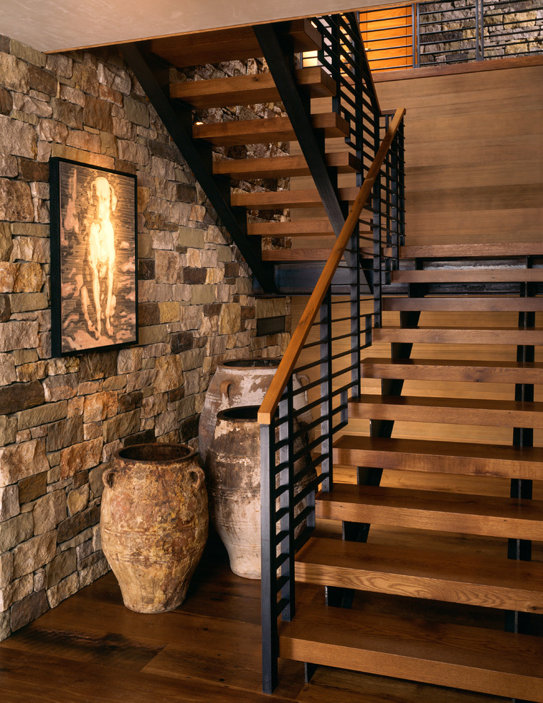 This is an example of a mid-sized country wood u-shaped staircase in Denver with open risers and mixed railing.