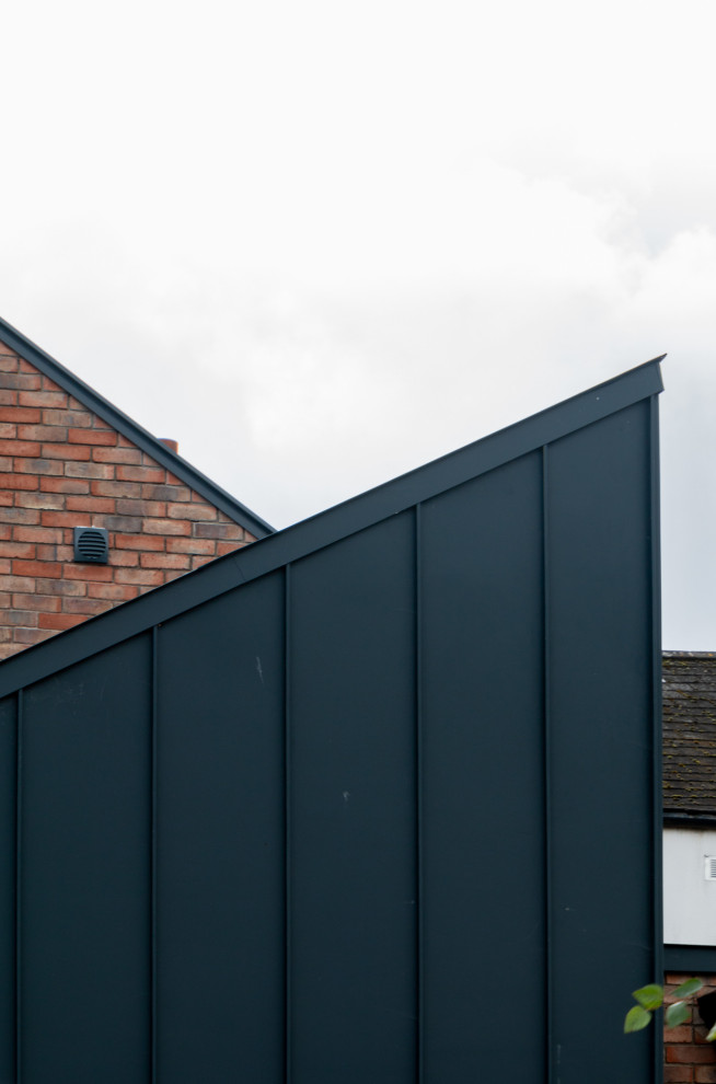 This is an example of a modern townhouse exterior in Dublin with a gable roof and a metal roof.