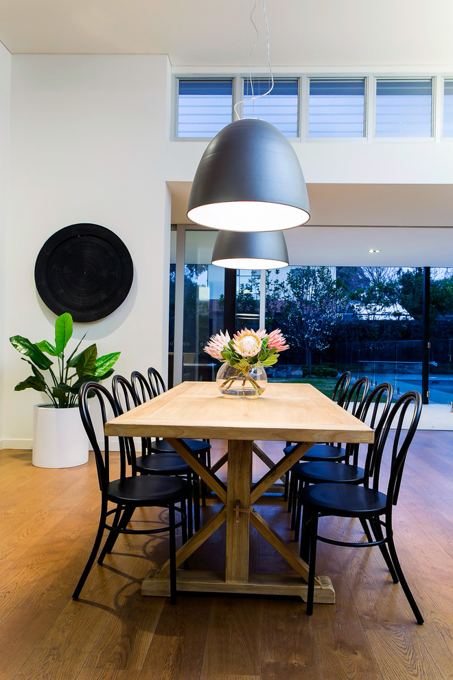 Contemporary dining room in Adelaide with white walls, medium hardwood floors and brown floor.