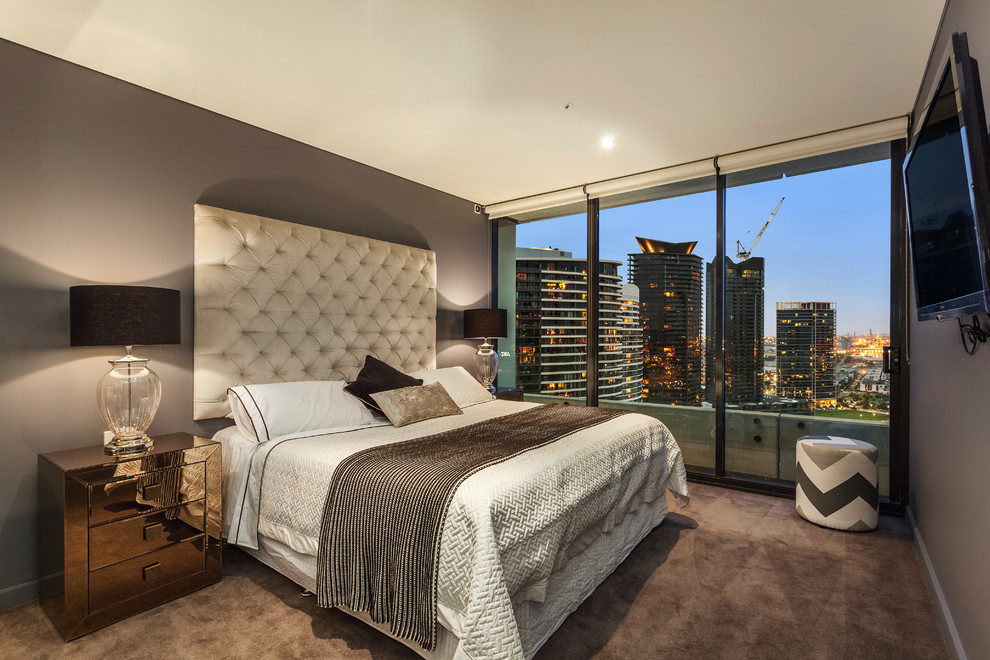 Photo of a large contemporary master bedroom in Melbourne with beige walls and carpet.
