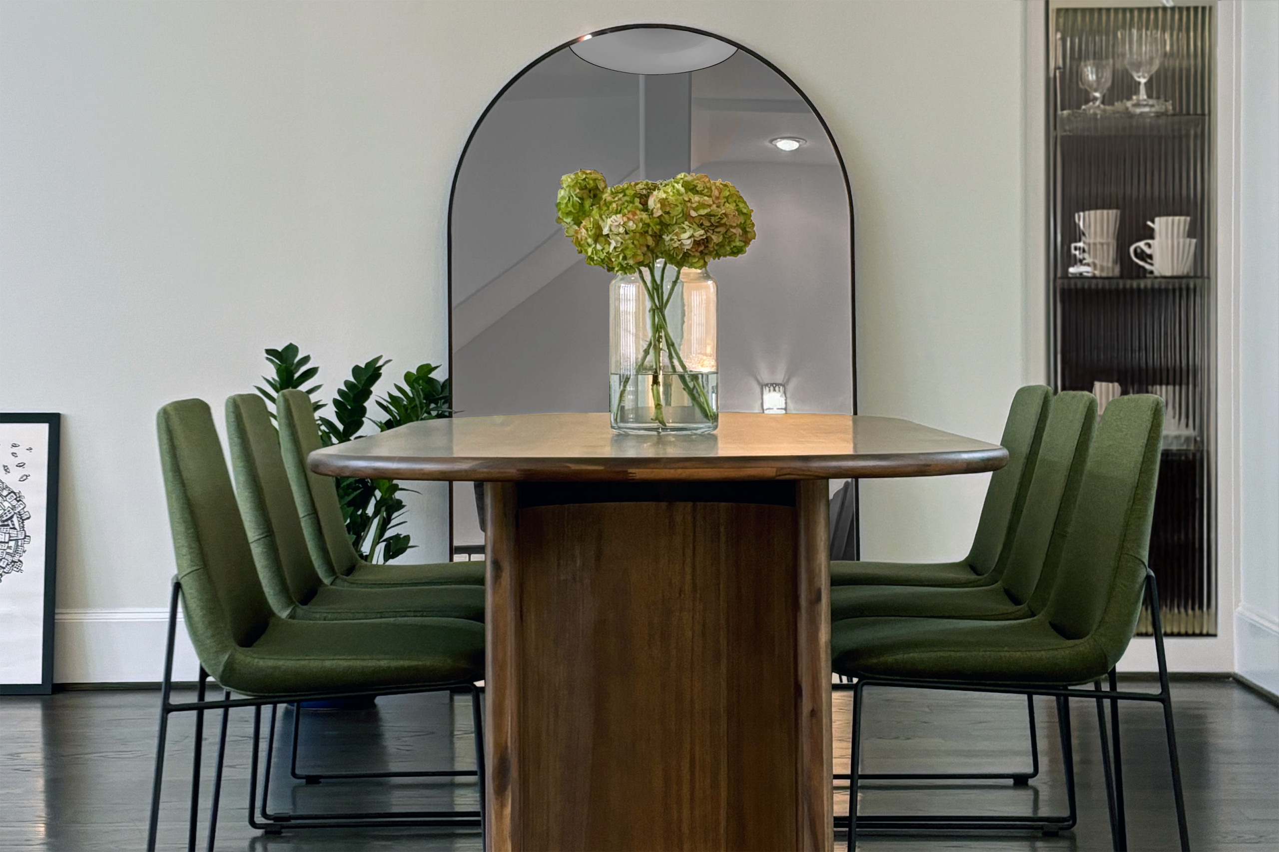 This dining area radiates timeless elegance with a modern edge. The centerpiece is a custom-crafted wooden dining table, seamlessly paired with plush green chairs that bring a refreshing pop of color.