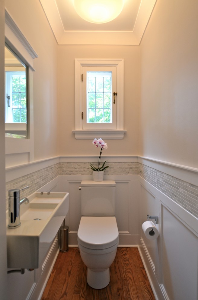 Photo of a small traditional powder room in Ottawa with a wall-mount sink, gray tile, matchstick tile, a two-piece toilet, beige walls and medium hardwood floors.