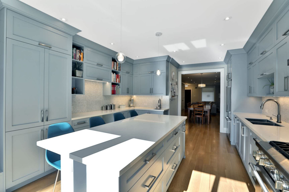 Modern inredning av ett avskilt, mellanstort vit vitt u-kök, med en undermonterad diskho, skåp i shakerstil, blå skåp, bänkskiva i kvarts, vitt stänkskydd, stänkskydd i mosaik, rostfria vitvaror, mellanmörkt trägolv, en köksö och gult golv