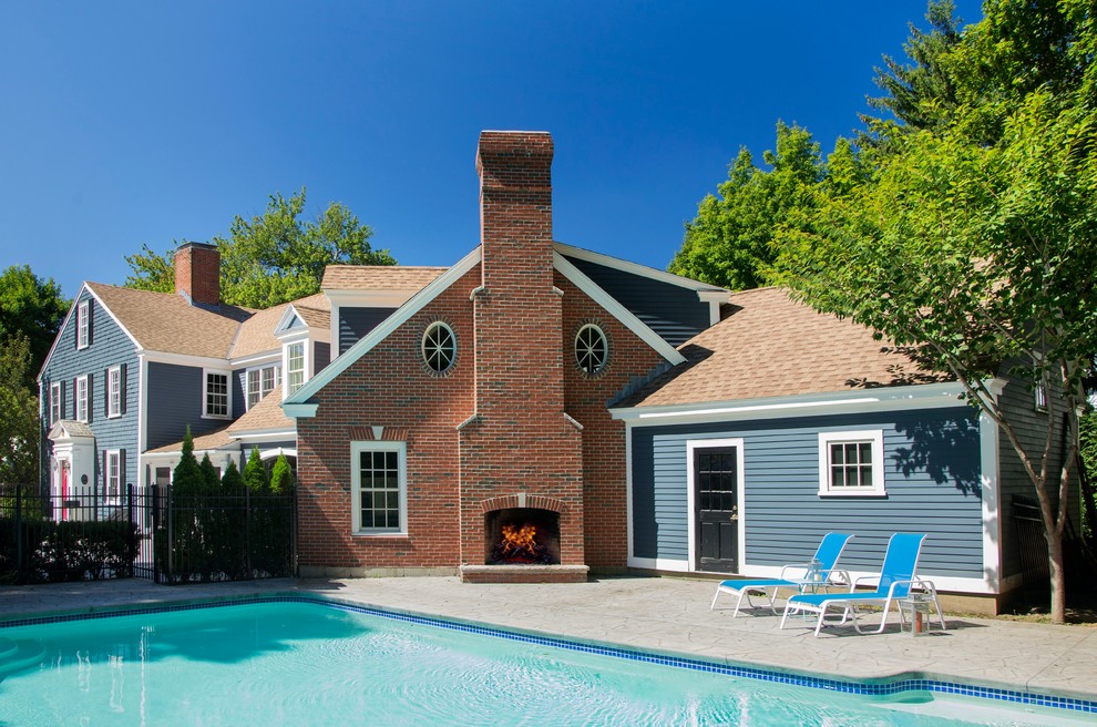 Mid-sized traditional backyard rectangular infinity pool in Boston with a pool house and concrete slab.