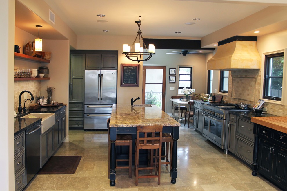 Photo of a large country galley eat-in kitchen in Los Angeles with a farmhouse sink, recessed-panel cabinets, grey cabinets, granite benchtops, beige splashback, cement tile splashback, stainless steel appliances, travertine floors and with island.