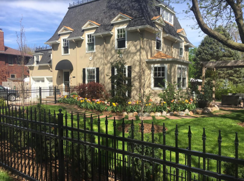 Large elegant yellow three-story concrete fiberboard house exterior photo in Omaha with a hip roof and a shingle roof