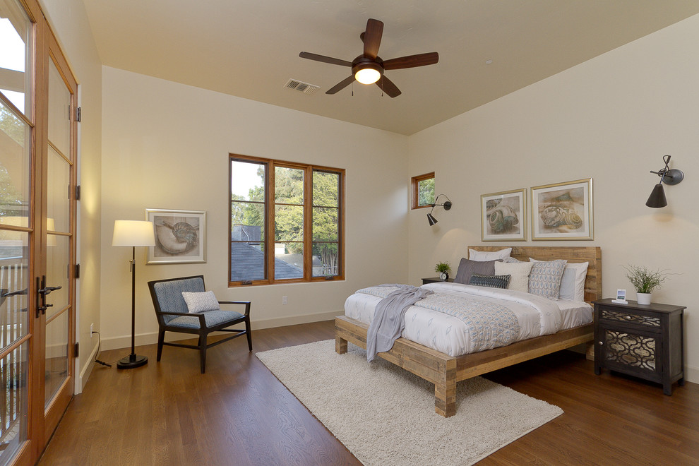 Design ideas for a mediterranean master bedroom in Sacramento with beige walls and medium hardwood floors.