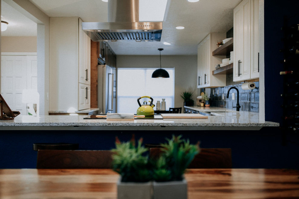 This is an example of a medium sized contemporary u-shaped kitchen/diner in Albuquerque with a belfast sink, dark wood cabinets, blue splashback, glass tiled splashback, stainless steel appliances, dark hardwood flooring, no island, brown floors and multicoloured worktops.