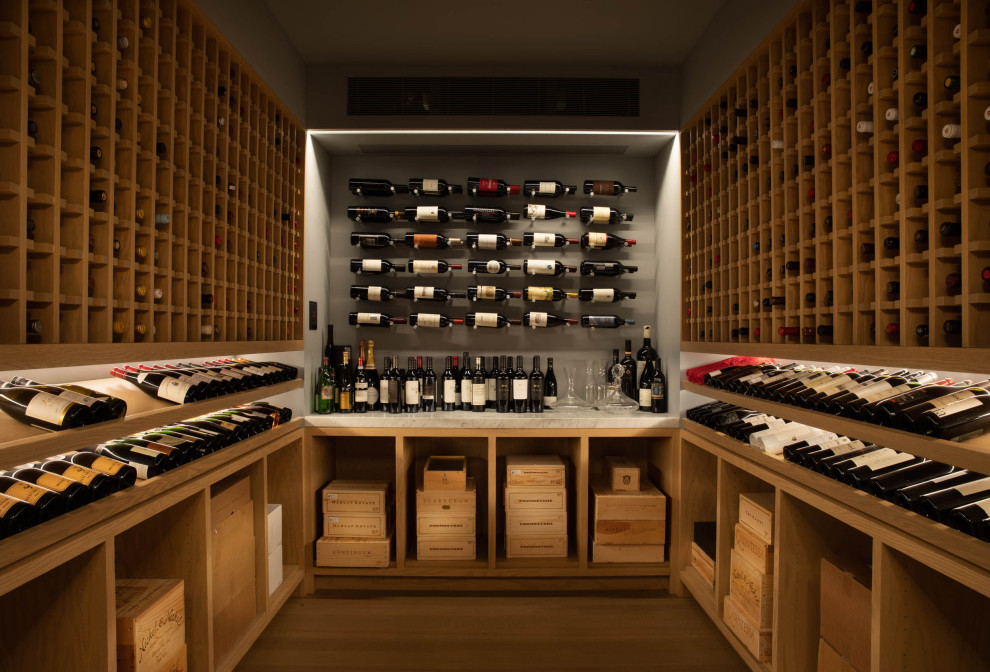 Design ideas for a large contemporary wine cellar in San Francisco with light hardwood floors, diamond bins and beige floor.
