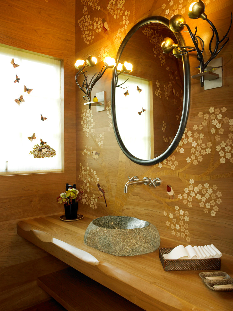 Asian powder room in London with a vessel sink, open cabinets, medium wood cabinets, wood benchtops and brown benchtops.