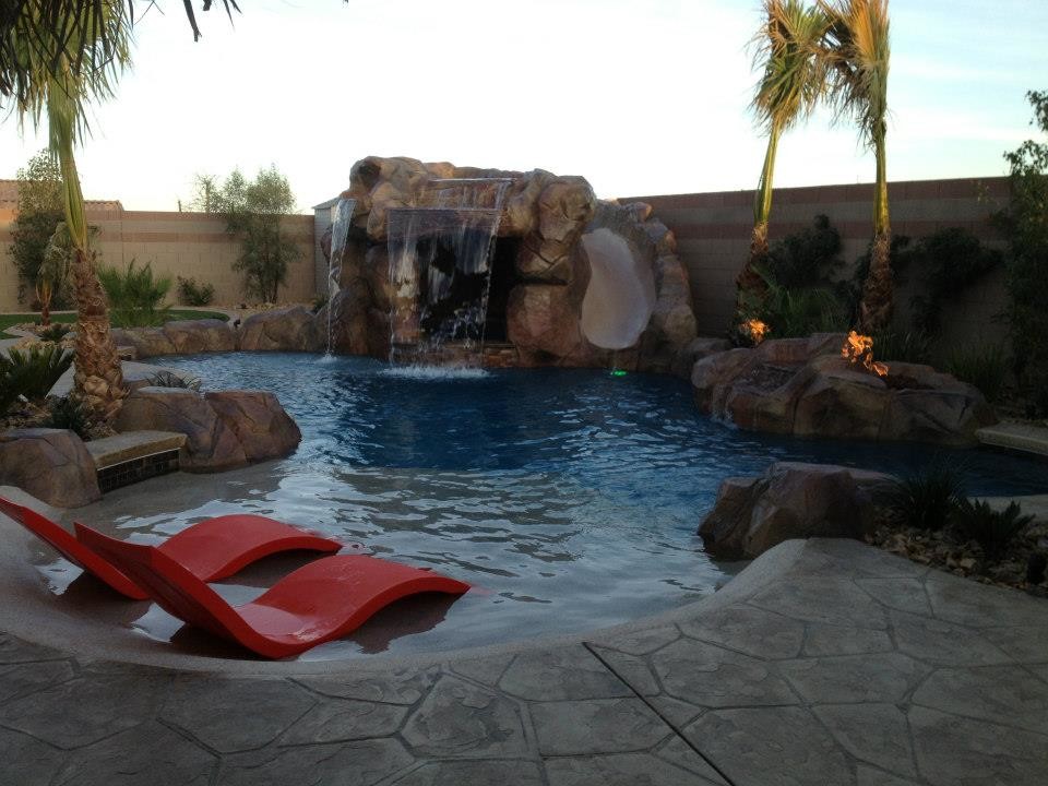 Pool fountain - large tropical backyard stone and custom-shaped lap pool fountain idea in Houston