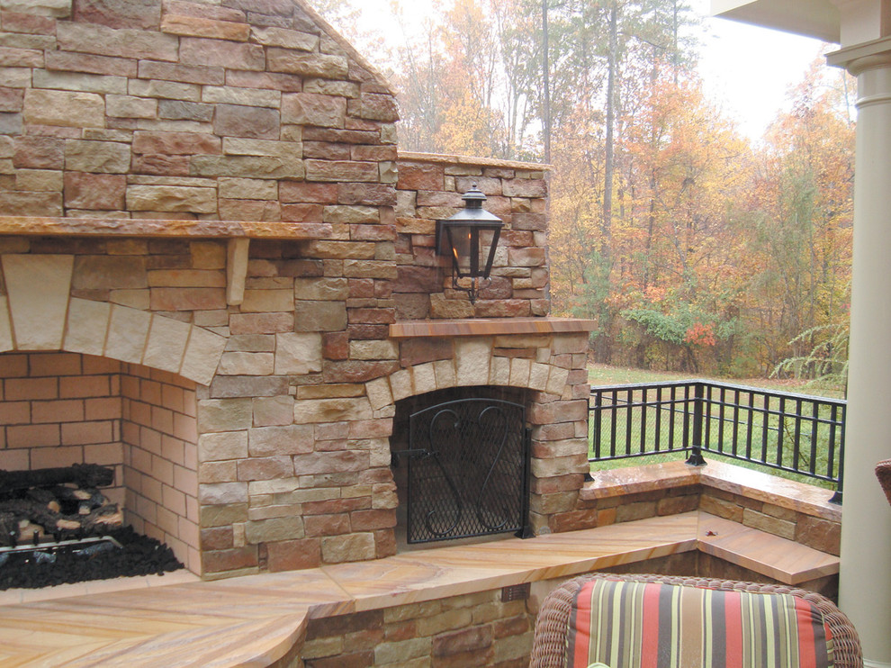 Mid-sized traditional backyard patio in Toronto with a fire feature, natural stone pavers and no cover.