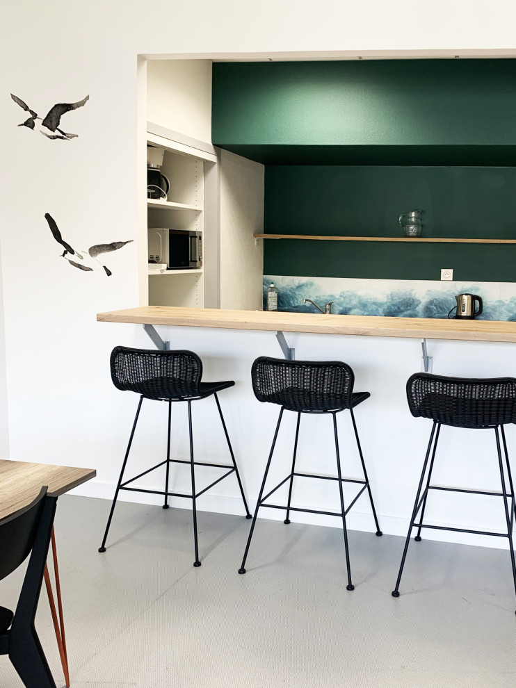 Photo of a modern single-wall seated home bar in Rennes with white cabinets, laminate benchtops, green splashback, laminate floors and grey floor.