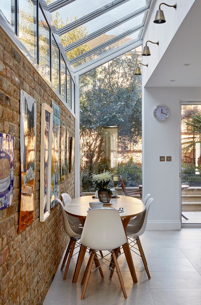 Photo of a transitional dining room in London with white walls and white floor.