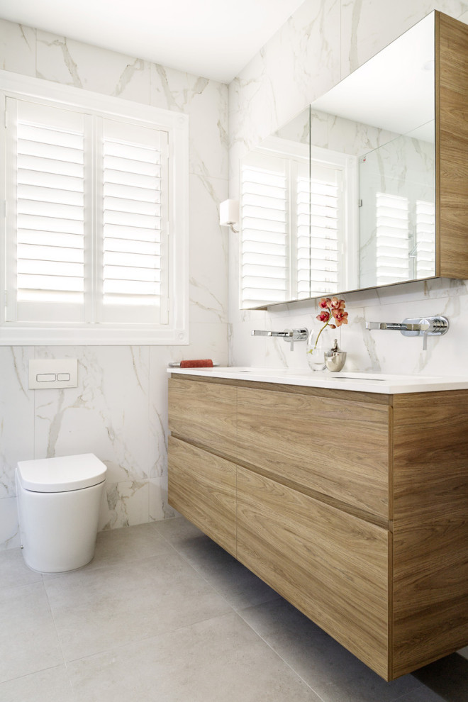 Photo of a small contemporary bathroom in Melbourne with medium wood cabinets, a double shower, a wall-mount toilet, porcelain floors, an undermount sink, engineered quartz benchtops, grey floor, an open shower and white benchtops.