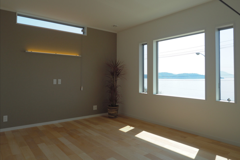 This is an example of a mid-sized modern master bedroom in Other with grey walls, light hardwood floors, beige floor, wallpaper and wallpaper.