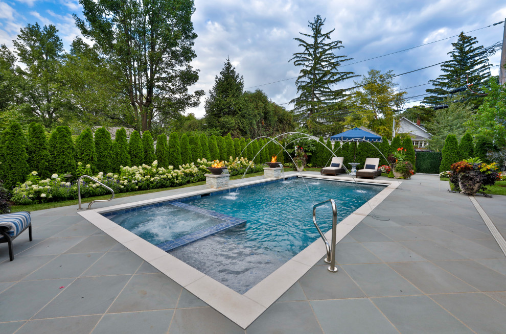 Design ideas for a mid-sized traditional backyard rectangular lap pool in Chicago with with privacy feature and natural stone pavers.