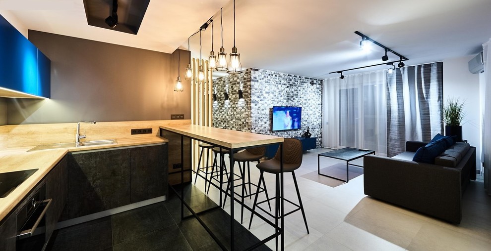 Small industrial l-shaped open plan kitchen in Moscow with a drop-in sink, flat-panel cabinets, black cabinets, laminate benchtops, timber splashback, coloured appliances, porcelain floors and no island.