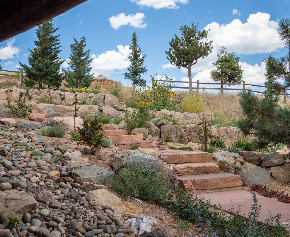Inspiration for a large rustic drought-tolerant and full sun hillside stone retaining wall landscape for summer.