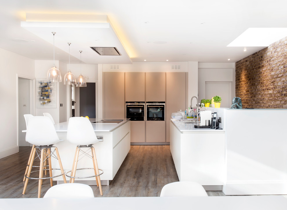 Design ideas for a contemporary kitchen in London with flat-panel cabinets, white cabinets, stainless steel appliances, light hardwood floors and with island.