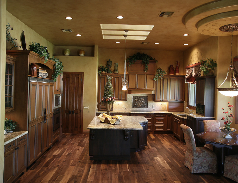 Inspiration for a traditional u-shaped eat-in kitchen in Phoenix with an undermount sink, brown cabinets, granite benchtops and panelled appliances.