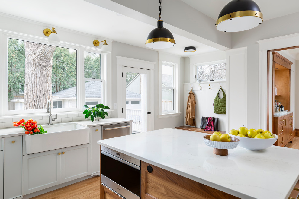 Eat-in kitchen - large transitional u-shaped light wood floor and beige floor eat-in kitchen idea in Minneapolis with a farmhouse sink, recessed-panel cabinets, blue cabinets, quartz countertops, multicolored backsplash, ceramic backsplash, stainless steel appliances, an island and white countertops