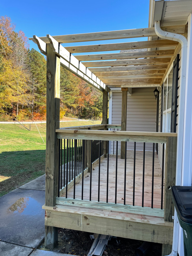 Photo of a small arts and crafts front yard verandah in Atlanta with a pergola and metal railing.