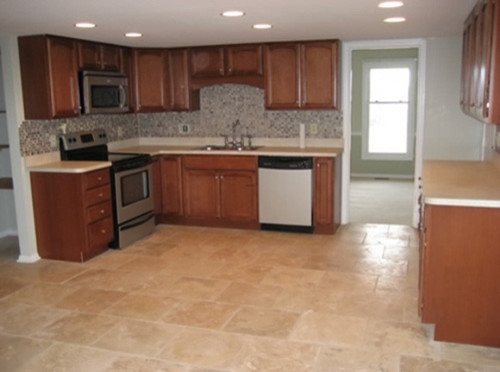 Photo of a mid-sized traditional l-shaped eat-in kitchen in DC Metro with a double-bowl sink, raised-panel cabinets, medium wood cabinets, granite benchtops, brown splashback, stone tile splashback, stainless steel appliances, ceramic floors and with island.