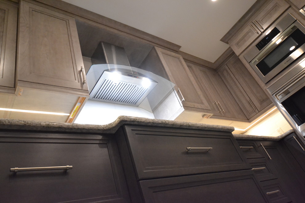 Inspiration for a mid-sized transitional u-shaped eat-in kitchen remodel in Toronto with recessed-panel cabinets and an island