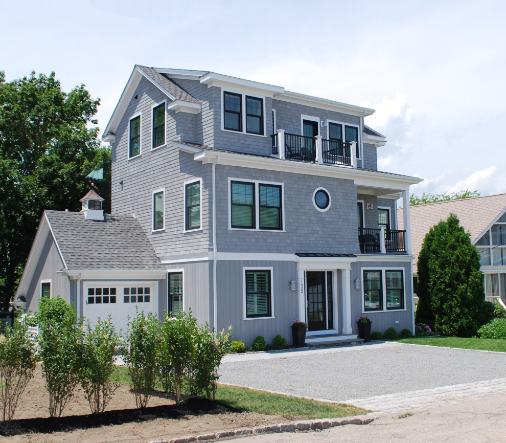 This is an example of a large beach style three-storey grey house exterior in Providence with wood siding and a gable roof.