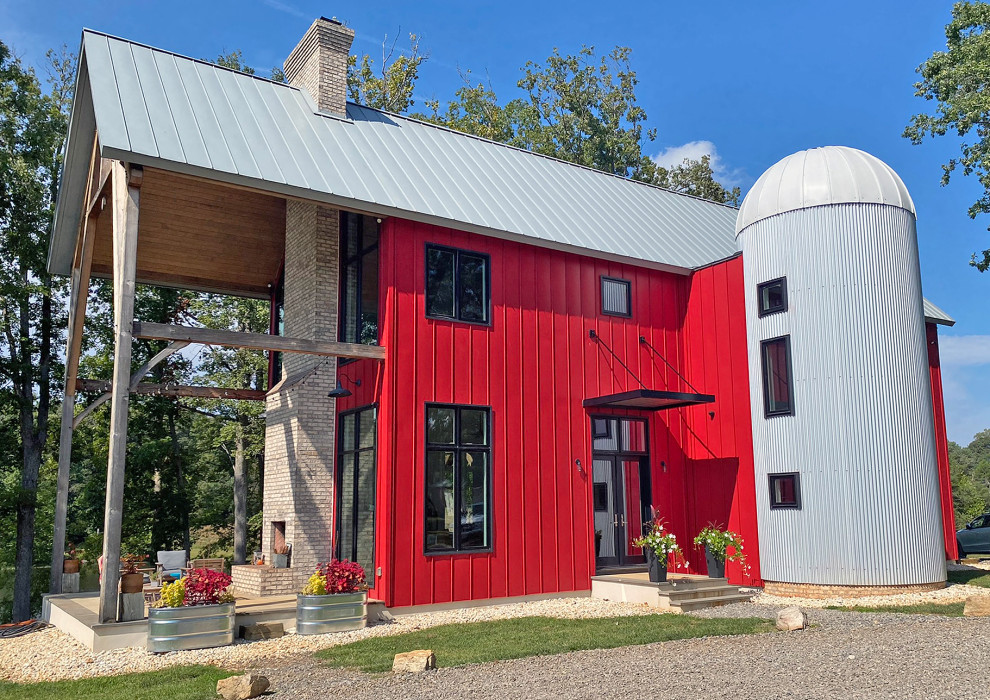Immagine della villa rossa moderna con rivestimento in metallo, tetto a capanna, copertura in metallo o lamiera e tetto grigio