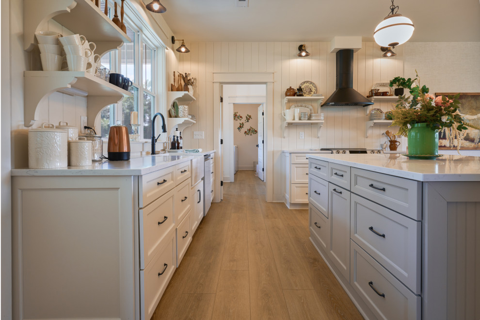 Mid-sized cottage chic u-shaped vinyl floor, beige floor and vaulted ceiling eat-in kitchen photo in Charlotte with a drop-in sink, beaded inset cabinets, white cabinets, marble countertops, white backsplash, ceramic backsplash, an island, white countertops and white appliances
