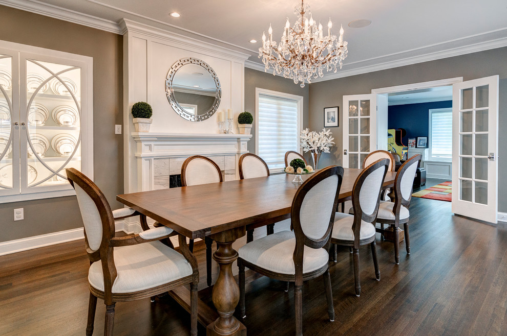 Inspiration for a large traditional separate dining room in Columbus with grey walls, dark hardwood floors, a standard fireplace and a stone fireplace surround.