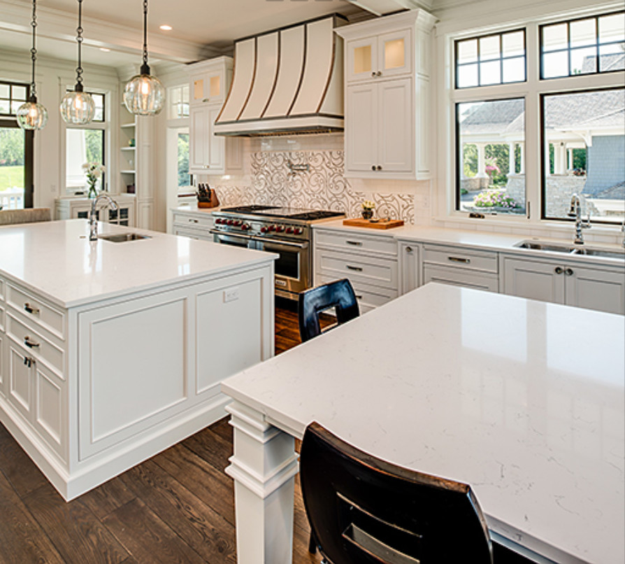 Example of a large transitional galley dark wood floor and brown floor open concept kitchen design with a double-bowl sink, recessed-panel cabinets, white cabinets, white backsplash, stainless steel appliances and two islands