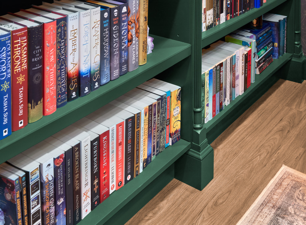 Esempio di un piccolo studio moderno con libreria, pavimento in legno massello medio, scrivania incassata, pavimento marrone e carta da parati