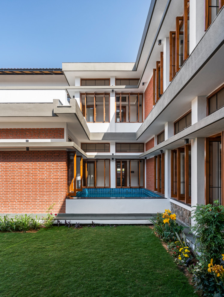 Inspiration for a large contemporary courtyard rectangular above ground swimming pool in Bengaluru with a water feature and natural stone paving.