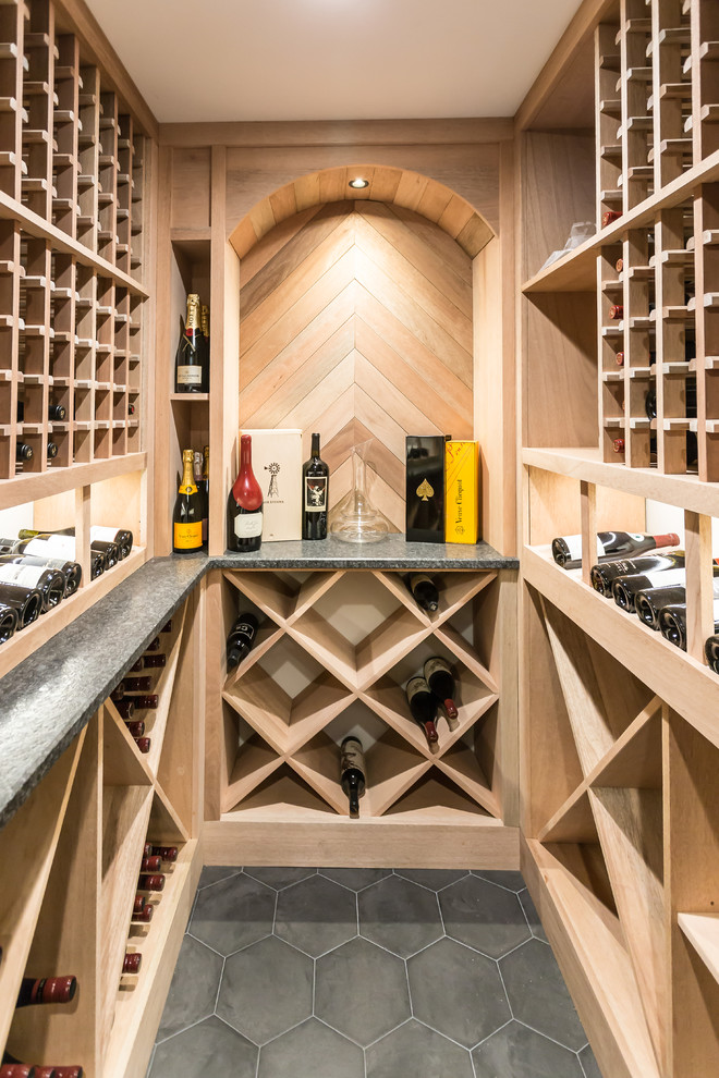 Photo of a transitional wine cellar in Philadelphia with diamond bins and grey floor.