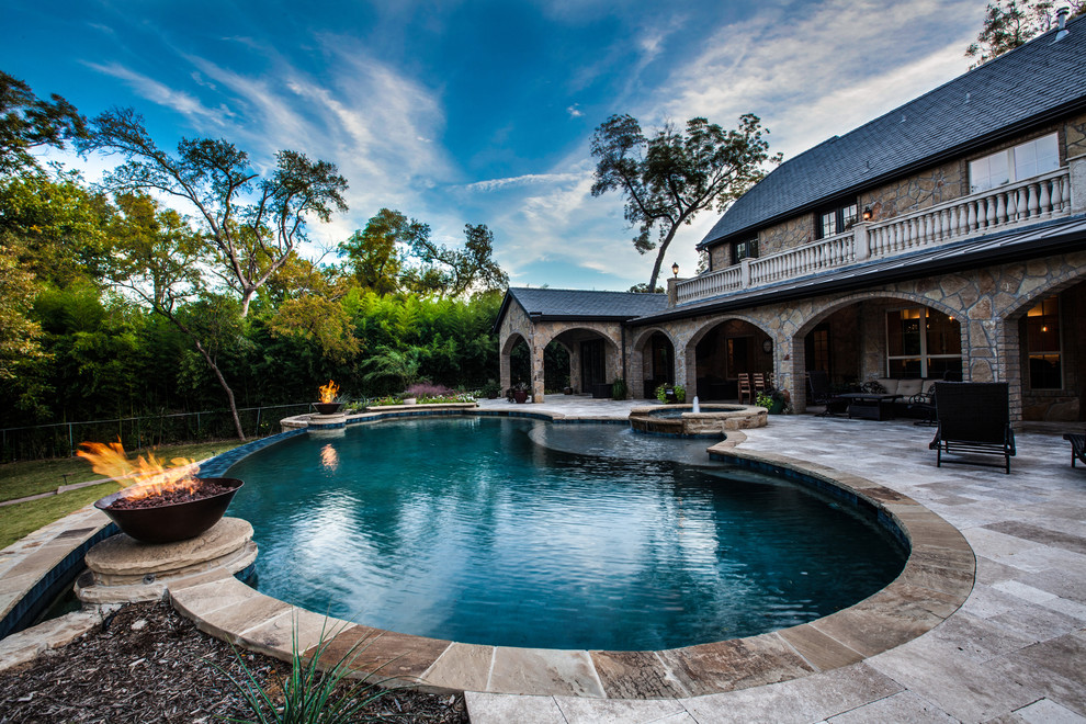 Large traditional backyard custom-shaped infinity pool in Dallas with a hot tub.