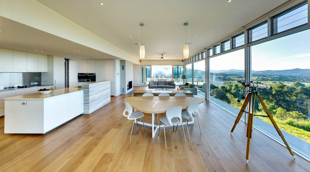 Design ideas for a large contemporary open concept living room in Gold Coast - Tweed with white walls, medium hardwood floors and a standard fireplace.