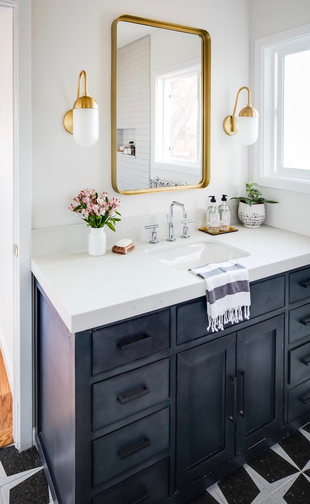This is an example of a mid-sized eclectic master bathroom in San Diego with a one-piece toilet, porcelain floors, an undermount sink, engineered quartz benchtops, white benchtops and black floor.