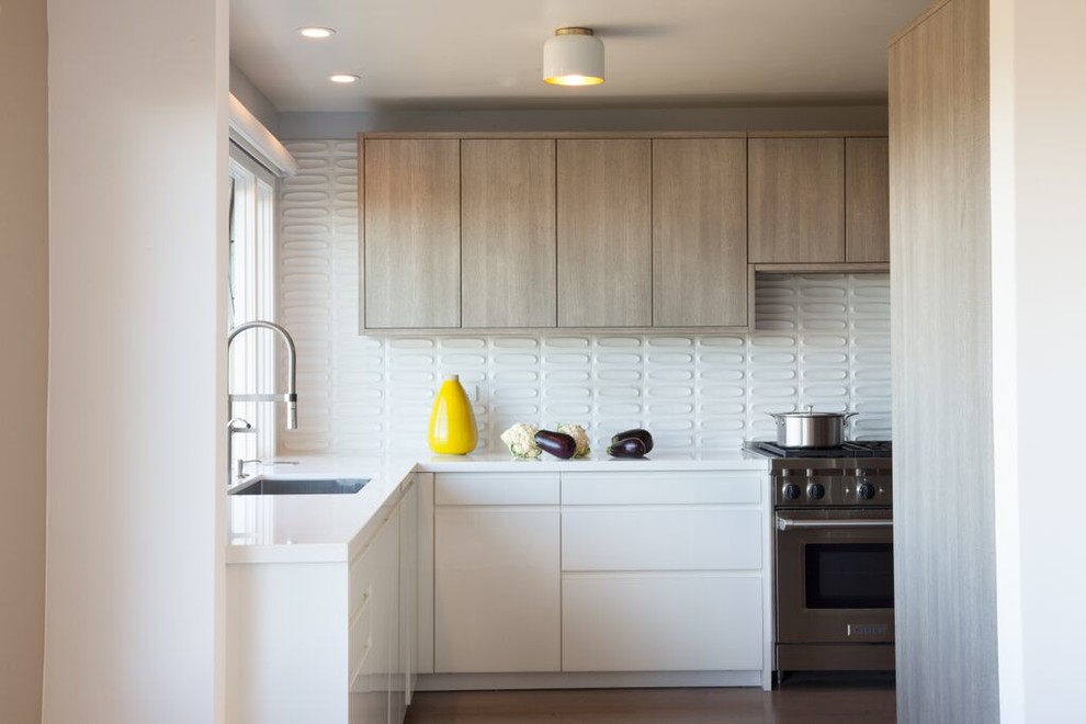 Design ideas for a midcentury galley separate kitchen in San Francisco with an undermount sink, flat-panel cabinets, light wood cabinets, solid surface benchtops, white splashback, ceramic splashback, stainless steel appliances and no island.
