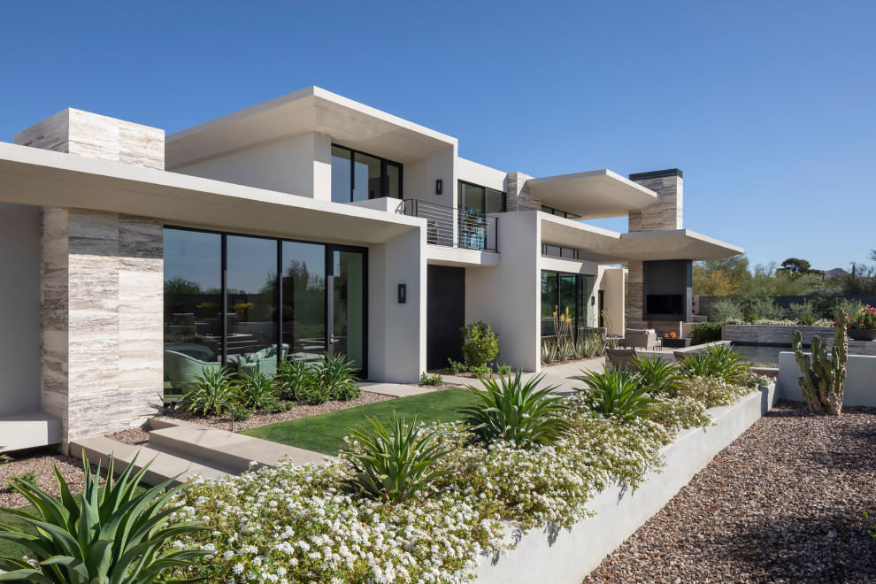 На фото: огромный, двухэтажный, белый частный загородный дом в стиле модернизм с облицовкой из камня и плоской крышей