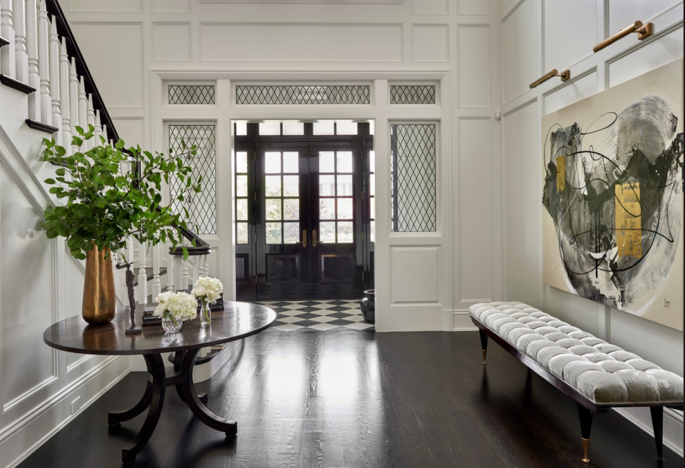 This is an example of an expansive beach style foyer in Chicago with white walls, dark hardwood flooring, a double front door, a black front door and brown floors.