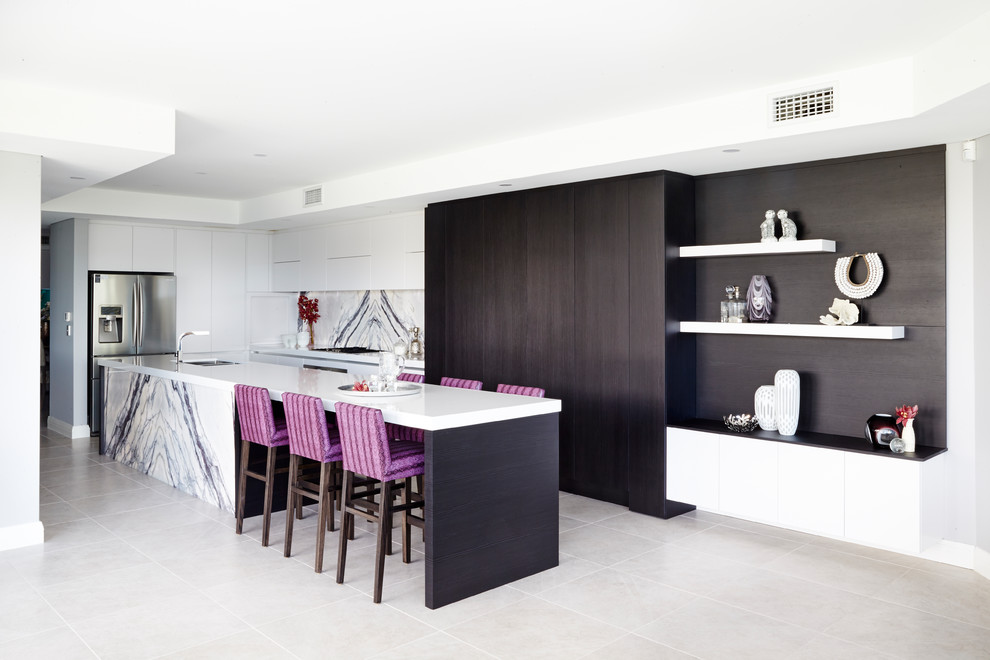 Inspiration for a large contemporary l-shaped kitchen in Sydney with a double-bowl sink, flat-panel cabinets, white cabinets, quartz benchtops, white splashback, stone slab splashback, stainless steel appliances, with island, white benchtop and grey floor.