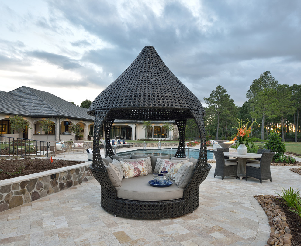 Expansive eclectic backyard patio in Houston with natural stone pavers.